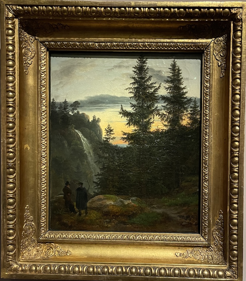 Two men watching a waterfall in the mountains.